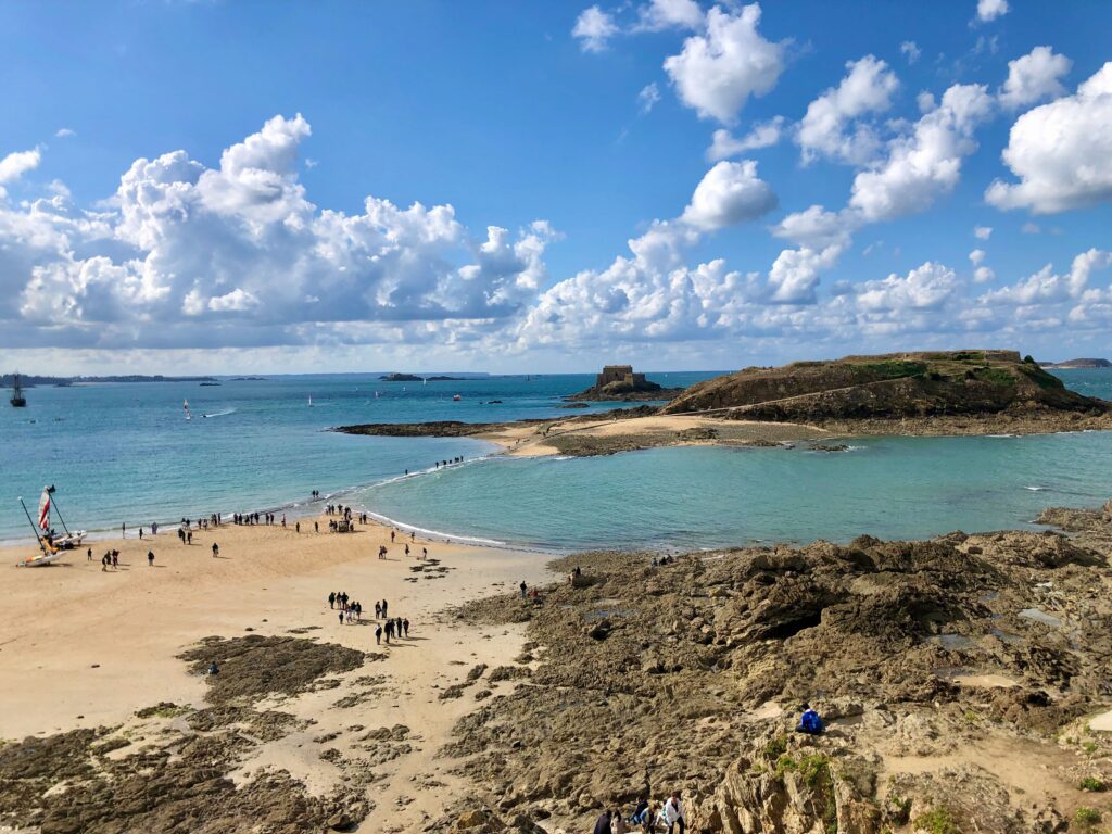 looking out at Grand Bé (Saint-Malo) as the tide is rising, causeway partially covered but people are still crossing by foot