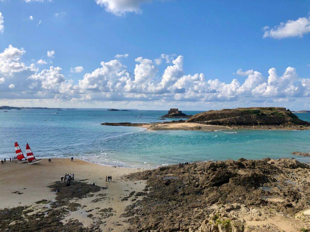 looking out at Grand Bé (Saint-Malo) as the tide is rising, causeway completely covered, group of people stuck on Grand Bé