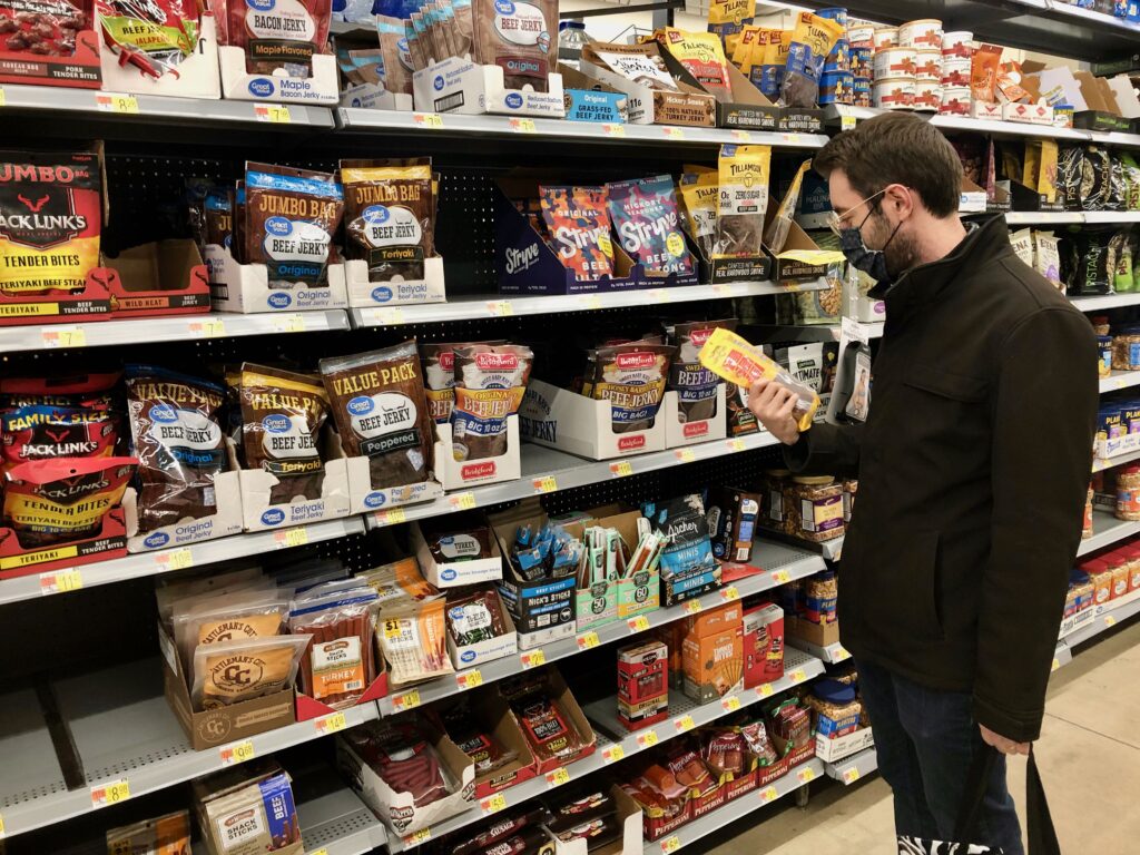 Frenchman examining beef jerky packets in a Walmart in the United States