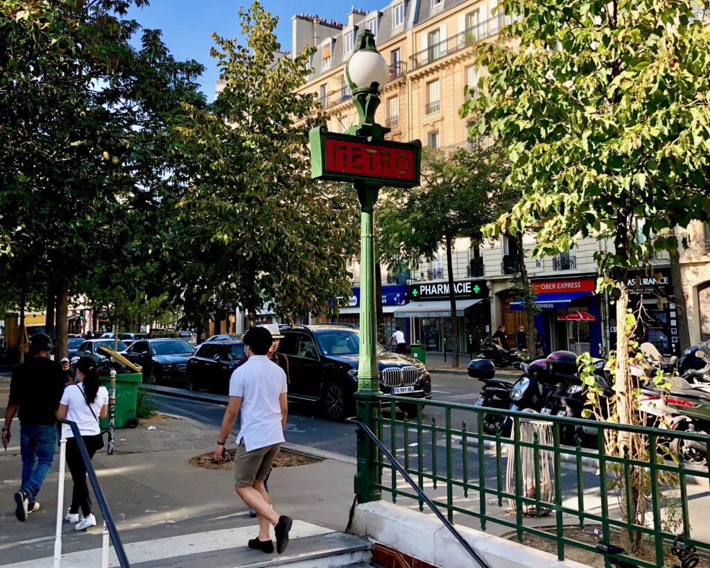 Green and red Metro sign indicating the entrance to a Paris subway