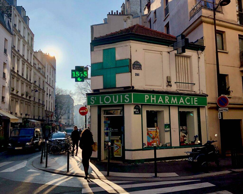 corner pharmacy in Paris with green cross symbol