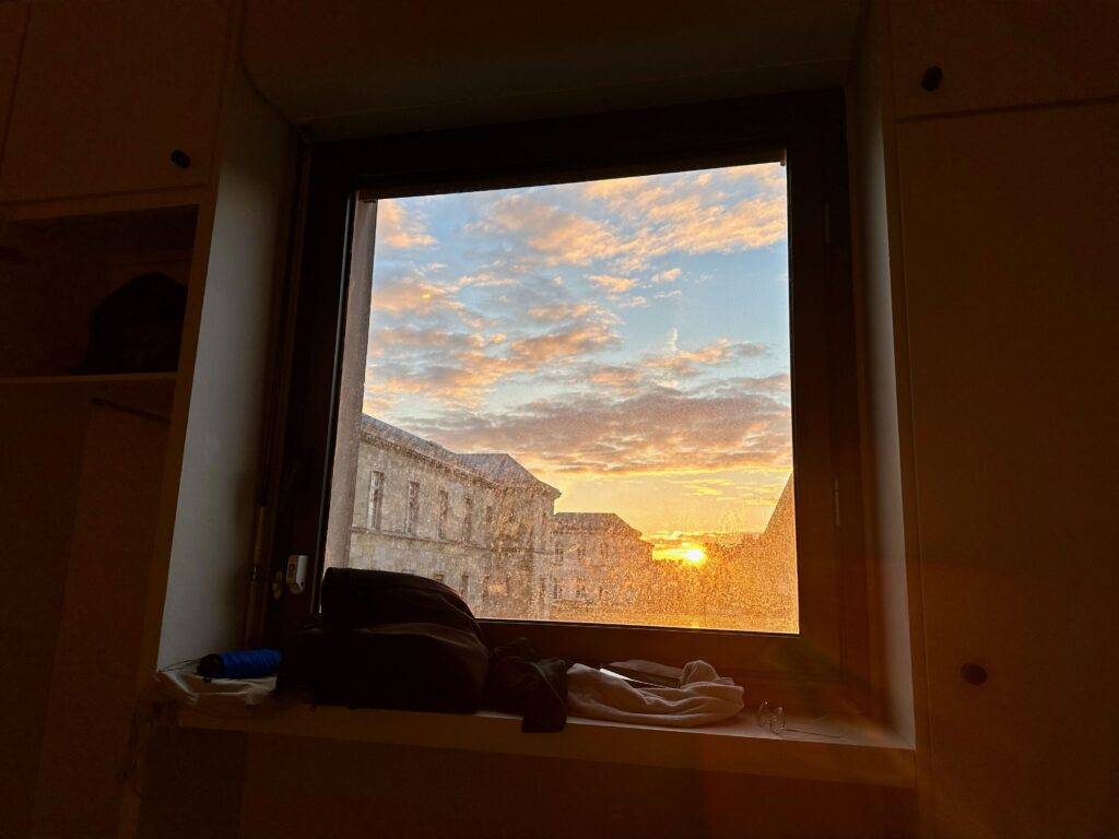 Sunrise view from a dirty window in a darkened room in the maternity ward of a Paris hospital, Lariboisière